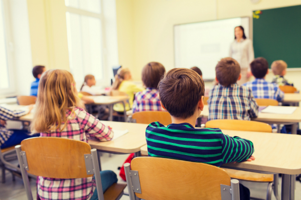  Una maestra de escuela primaria da conferencias al frente de su clase