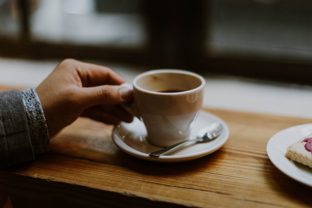 Hand holding a coffee cup.