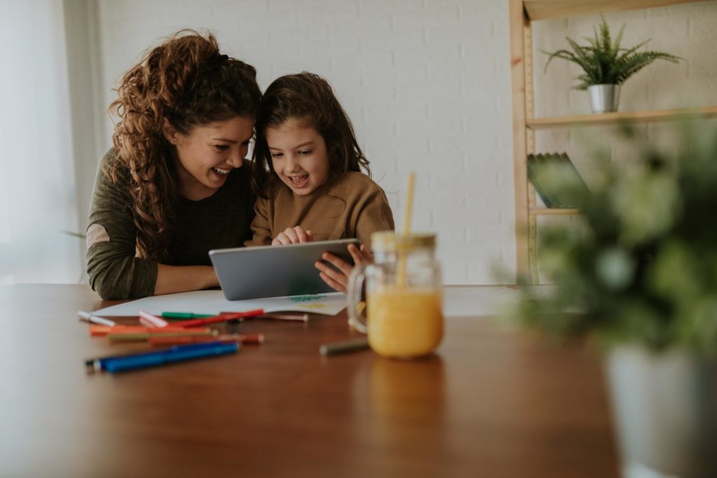 Mother and child playing on tablet together.