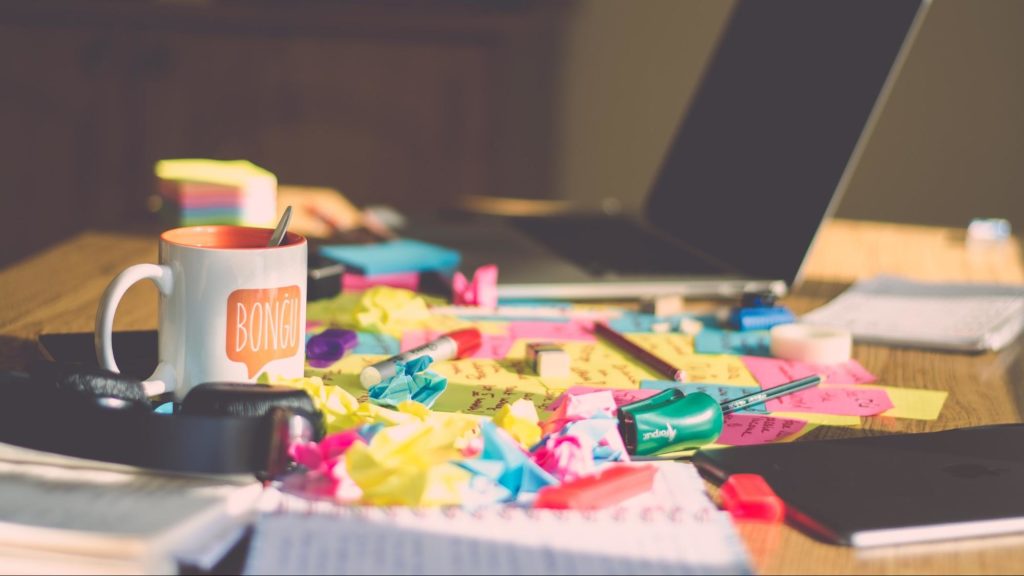 Messy desk covered in post-it notes.