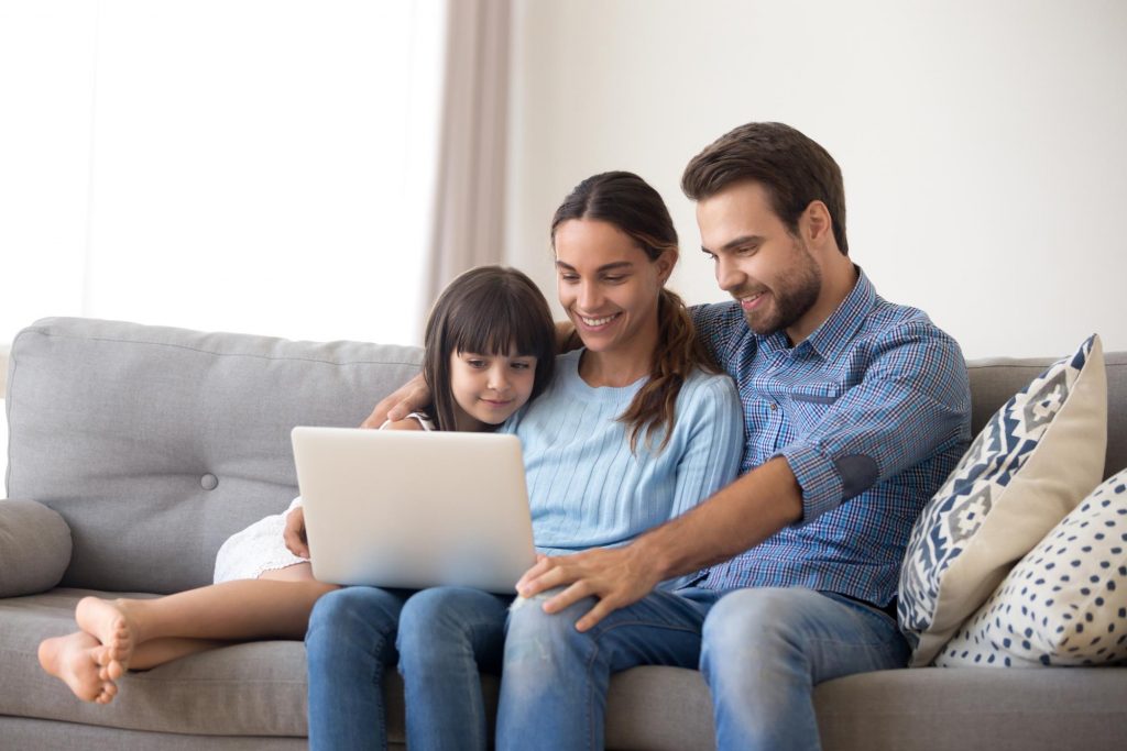 Child looking at computer with two parents